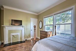 een slaapkamer met een bed, een open haard en een tv bij Cozy Greenville Bungalow about 2 Mi to Downtown! in Greenville