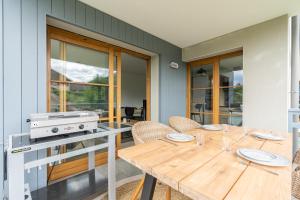uma sala de jantar com uma mesa de madeira e cadeiras em Talloires Village, Lac d'Annecy, Résidence récente 4 étoiles em Talloires
