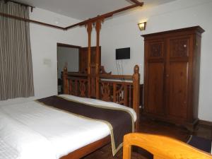 a bedroom with a bed and a dresser at Maison Petite Singapore in Pondicherry
