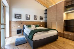 a bedroom with a large bed with wooden walls at Alpine View Plan de Corones in Sorafurcia
