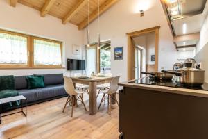 a kitchen and living room with a couch and a table at Alpine View Plan de Corones in Sorafurcia