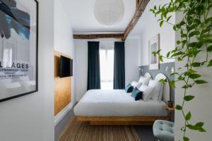 a bedroom with a bed with white sheets and blue curtains at Baba Hotel in Paris