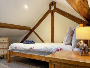 um quarto com uma cama com uma estrutura em madeira em Damsels Bower em Bakewell