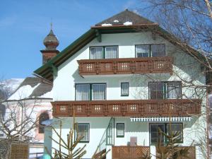 a large white building with a wooden balcony at Haus Bauer Appartment II mit Balkon in Mariapfarr