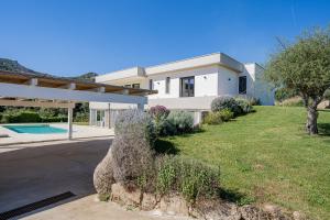 une grande maison blanche avec une cour et une allée. dans l'établissement Villa Green - Sardegna, à Calangianus