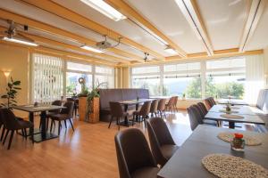 a restaurant with tables and chairs and large windows at Panorama Hotel Winterberg in Winterberg