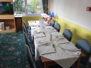 a row of tables with silverware on them in a room at The Sandhill in Sandown