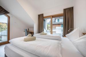 two beds in a room with a large window at App Dolomiten Villa Colli in Valdaora