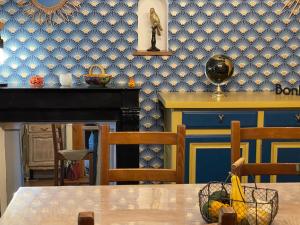 une salle à manger avec une table et un mur bleu dans l'établissement Gîte du centre, à Romorantin-Lanthenay