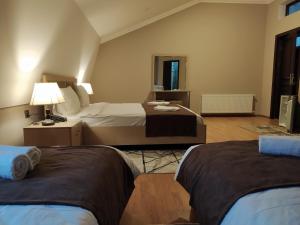 una habitación de hotel con 2 camas y una lámpara en Gold Hotel Quba, en Quba