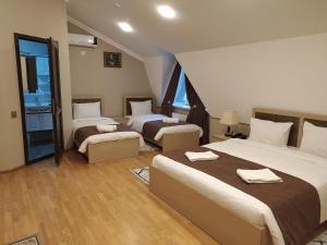 Habitación de hotel con 2 camas y ventana en Gold Hotel Quba, en Quba