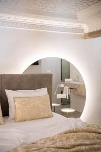 Schlafzimmer mit einem Bett und einem runden Spiegel in der Unterkunft Elia Erato in Chania