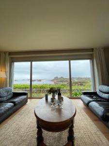 sala de estar con mesa y ventana grande en Vacances paradisiaques au coeur de l'Ile de Bréhat, en Bréhat