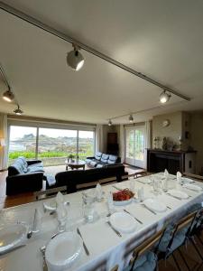 - une grande table avec des assiettes et de la vaisselle dans une pièce dans l'établissement Vacances paradisiaques au coeur de l'Ile de Bréhat, sur l'Île-de-Bréhat