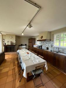 een grote keuken met een lange tafel in een kamer bij Vacances paradisiaques au coeur de l'Ile de Bréhat in Bréhat