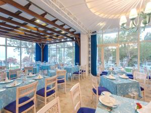 a dining room with blue tables and chairs and windows at Sherwood Exclusive Kemer - Kids Concept in Kemer