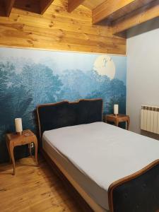 ein Schlafzimmer mit einem Bett und einem Wandgemälde in der Unterkunft Adorable petit châlet près de la forêt et des commerces in Montivilliers