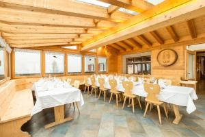 una sala da pranzo con tavoli e sedie bianchi di Heuberge a Fideris Dorf