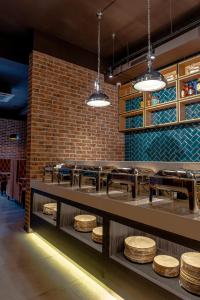 a restaurant with wooden stools and a brick wall at Resident Hotel Kazybek Bi in Almaty