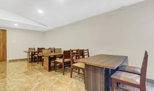uma sala de jantar com mesas e cadeiras de madeira em Treebo Trend Darwesh Residency em Calecute