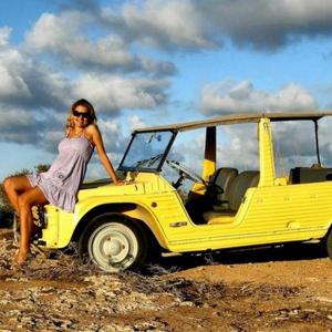 a woman in a dress sitting on a yellow jeep at Oasi Di Casablanca in Lampedusa