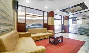 Sala de estar con 2 sofás y mesa en Treebo Trend Darwesh Residency en Kozhikode
