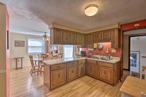 a kitchen with wooden cabinets and a dining room at Lakefront Ludington Retreat with Kayaks and Fire Pit! in Ludington