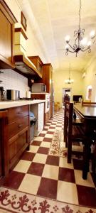 uma grande cozinha com piso em xadrez em Ta Majsi farmhouse with indoor heated pool em San Lawrenz