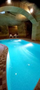 a large swimming pool with two chairs next to it at Ta Majsi farmhouse with indoor heated pool in San Lawrenz