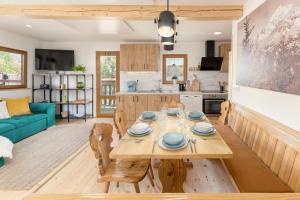 cocina y sala de estar con mesa de madera y sillas en Captain's Lodge, en Bohinj