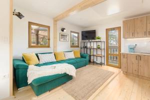 uma sala de estar com um sofá verde e uma cozinha em Captain's Lodge em Bohinj