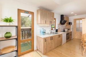 una cocina con armarios de madera y fregadero en Captain's Lodge, en Bohinj