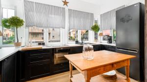 a kitchen with black cabinets and a wooden table at VacationClub - Kościelna 2 Apartament 4 in Karpacz +17 photos