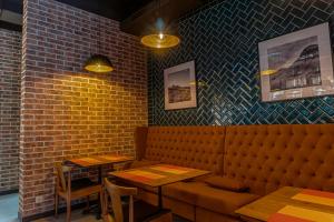 a restaurant with a bench and tables and a brick wall at Resident Hotel Kazybek Bi in Almaty