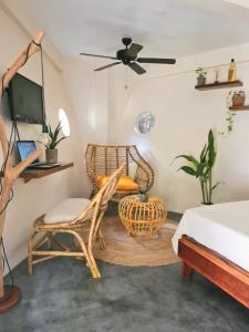 1 dormitorio con silla, escritorio y cama en Happiness Beach Resort Siargao, en General Luna