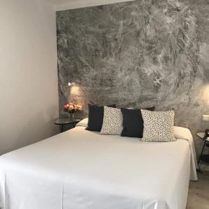 a bedroom with a large white bed with two pillows at Hotel Restaurant Bon Retorn in Figueres