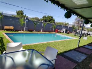 una piscina en un patio con sillas alrededor en Rufaro Hotel, Conference & Spa, en Burgersfort