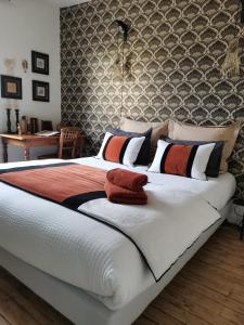 a bedroom with a large white bed with red pillows at La Maison de Ville in Compiègne