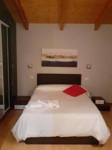 ein Schlafzimmer mit einem weißen Bett mit einer roten Decke in der Unterkunft Ciudad Rodrigo La Casa Azul in Ciudad-Rodrigo