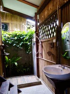 a bathroom with a sink and a plant at Phoxay Ngam Resort in Vang Vieng