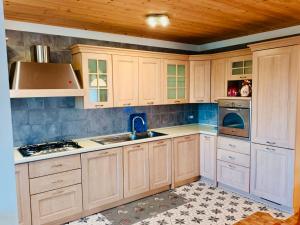 uma cozinha com armários de madeira e um forno com placa de fogão em Delizioso appartamento a Canove di Roana em Camporovere