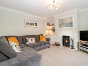 a living room with a couch and a fireplace at Curlew Cottage in Lymington