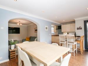a dining room and kitchen with a table and chairs at Curlew Cottage in Lymington