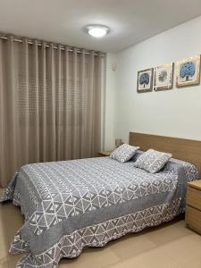 a bedroom with a bed with a blanket and pillows at 2 Avinguda Santa Clotilde in Lloret de Mar