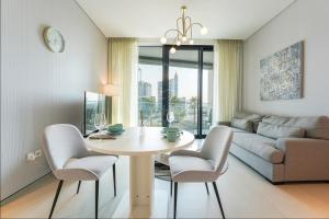 ein Wohnzimmer mit einem Tisch, Stühlen und einem Sofa in der Unterkunft KeyHost - Exquisite 1BR - The Address Beach Residences JBR - K350 in Dubai