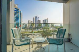 einen Balkon mit Stühlen und einem Tisch sowie Stadtblick in der Unterkunft KeyHost - Exquisite 1BR - The Address Beach Residences JBR - K350 in Dubai