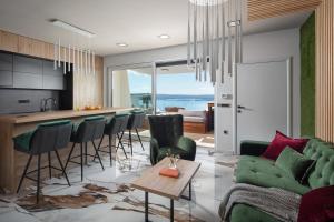 a kitchen and living room with a green couch and chairs at Villa SPA in Dramalj