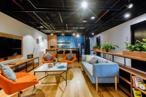 a living room with orange chairs and a couch at Hello World Saigon in Ho Chi Minh City