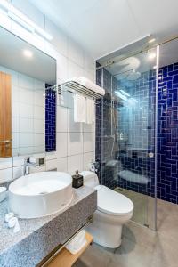 a bathroom with a sink and a toilet and a shower at Hello World Saigon in Ho Chi Minh City