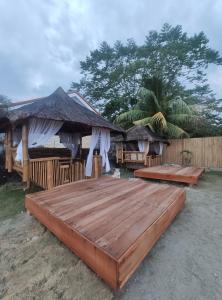 a wooden deck with chairs and umbrellas on the beach at SEAVIEW BEACH RESORT in Sibulan